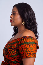 Detailed shot of the elasticated off shoulder neckline framing the collarbone on a premium Ankara wedding guest dress