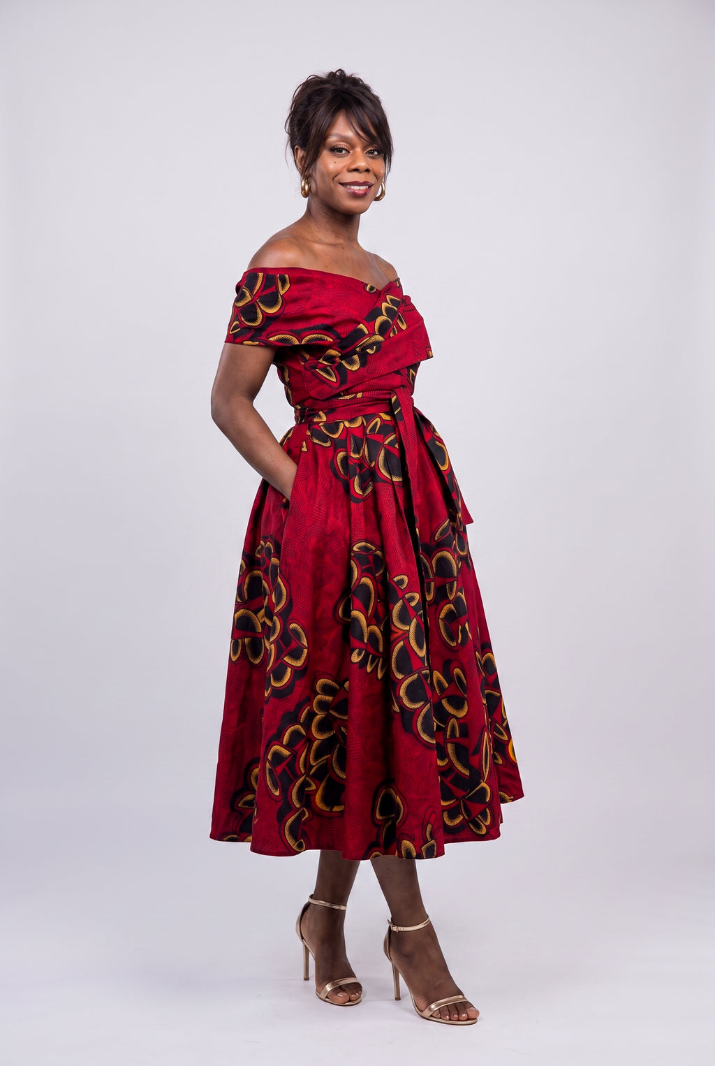 Side profile view of a  model wearing the fit and flare red African dress