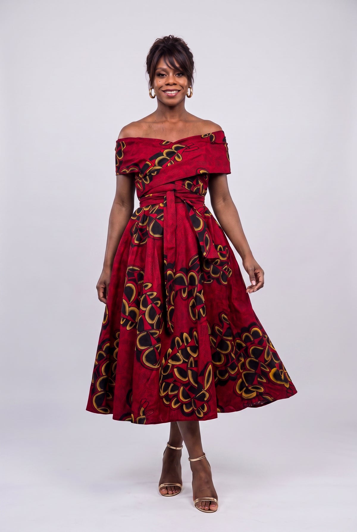 Walking in red African print midi off shoulder dress showing skirt movement