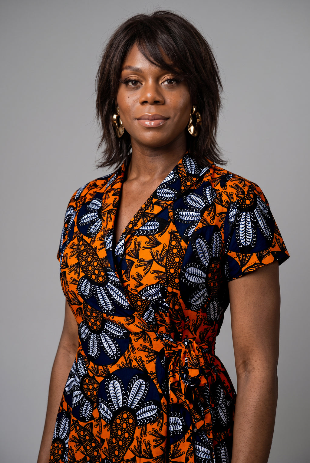 Side view of orange and navy Ankara wrap midi dress