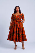  Model wearing Amber Horizon orange African print Ankara off shoulder dress with a full 