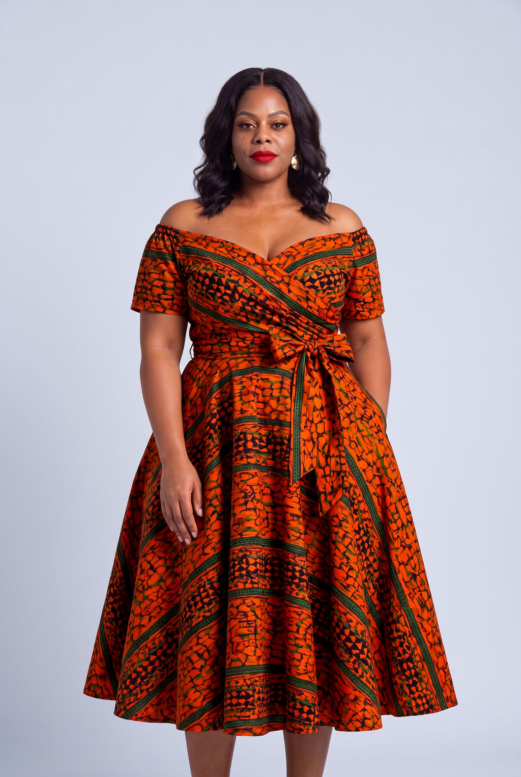 Half length of the orange green and navy Ankara wax print on the Amber Horizon dress