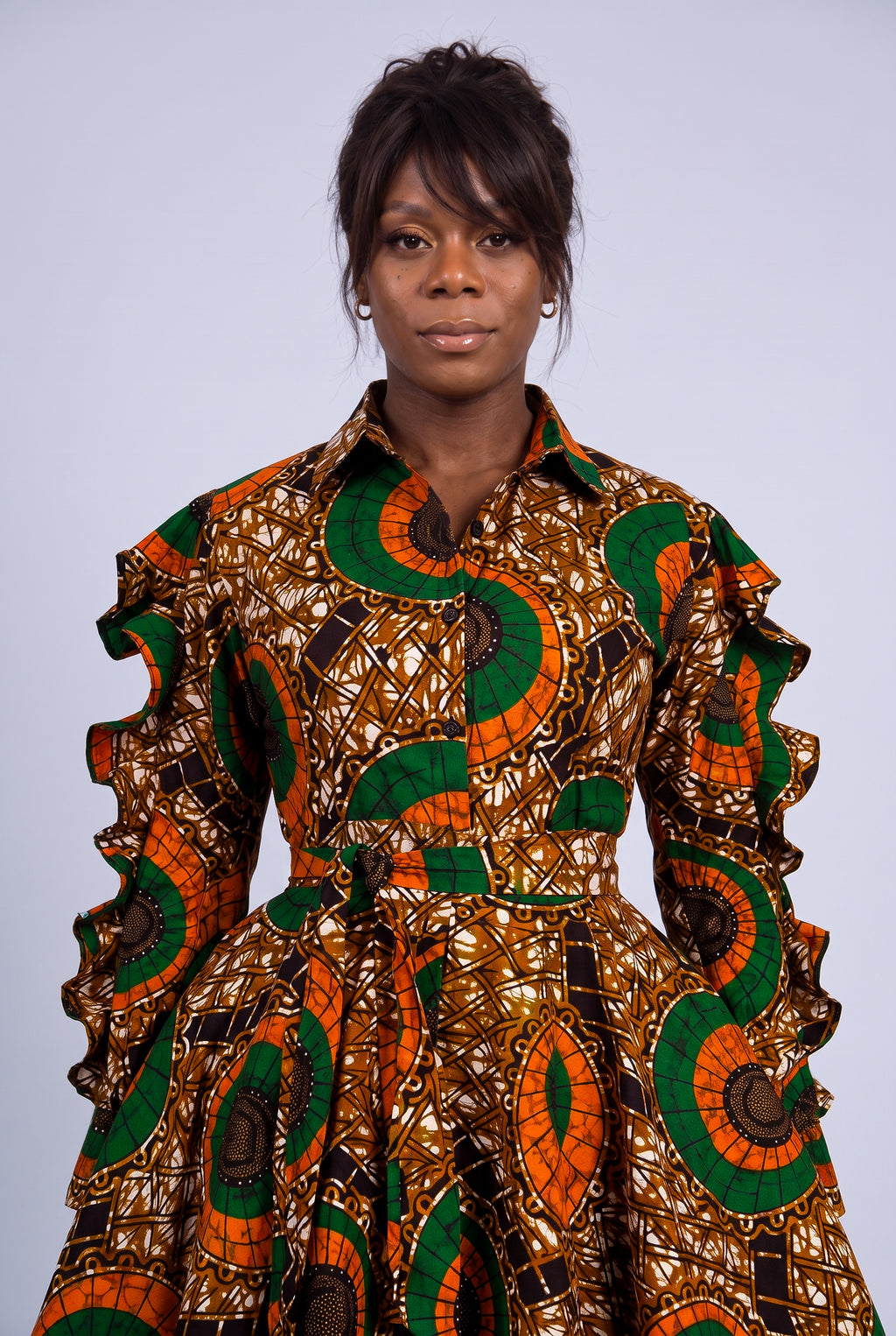 Close-up portrait of a model highlighting the classic point collar and button-through detail of an African wax print dress