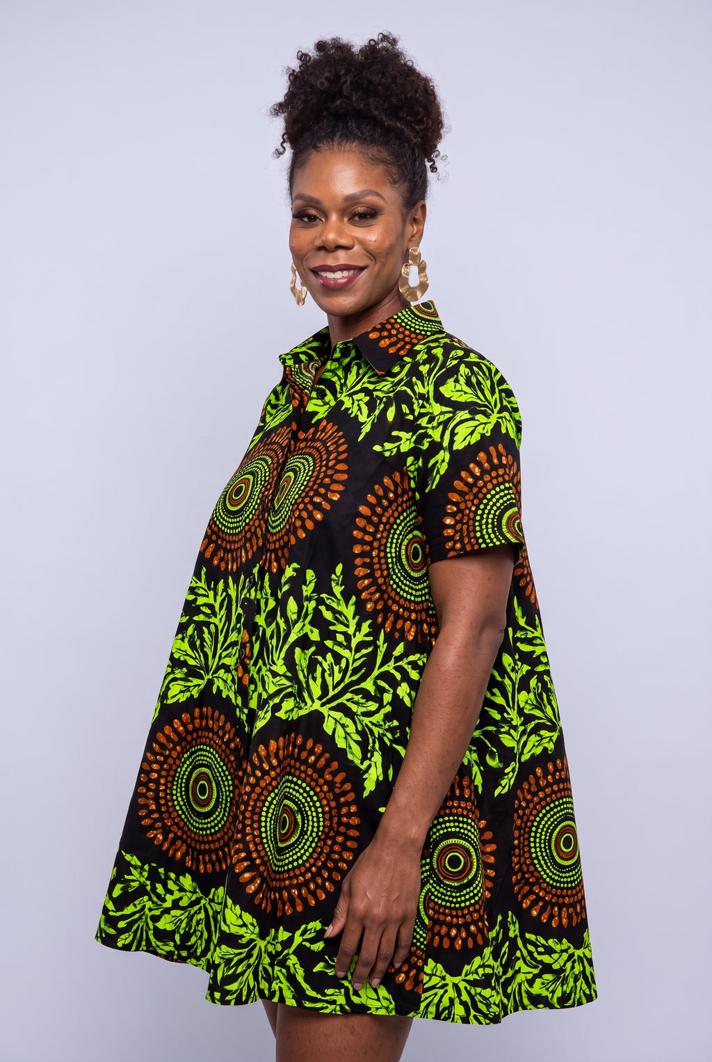 Close three quarter view of Lime Orbit black and lime green Ankara swing shirt dress with short sleeves