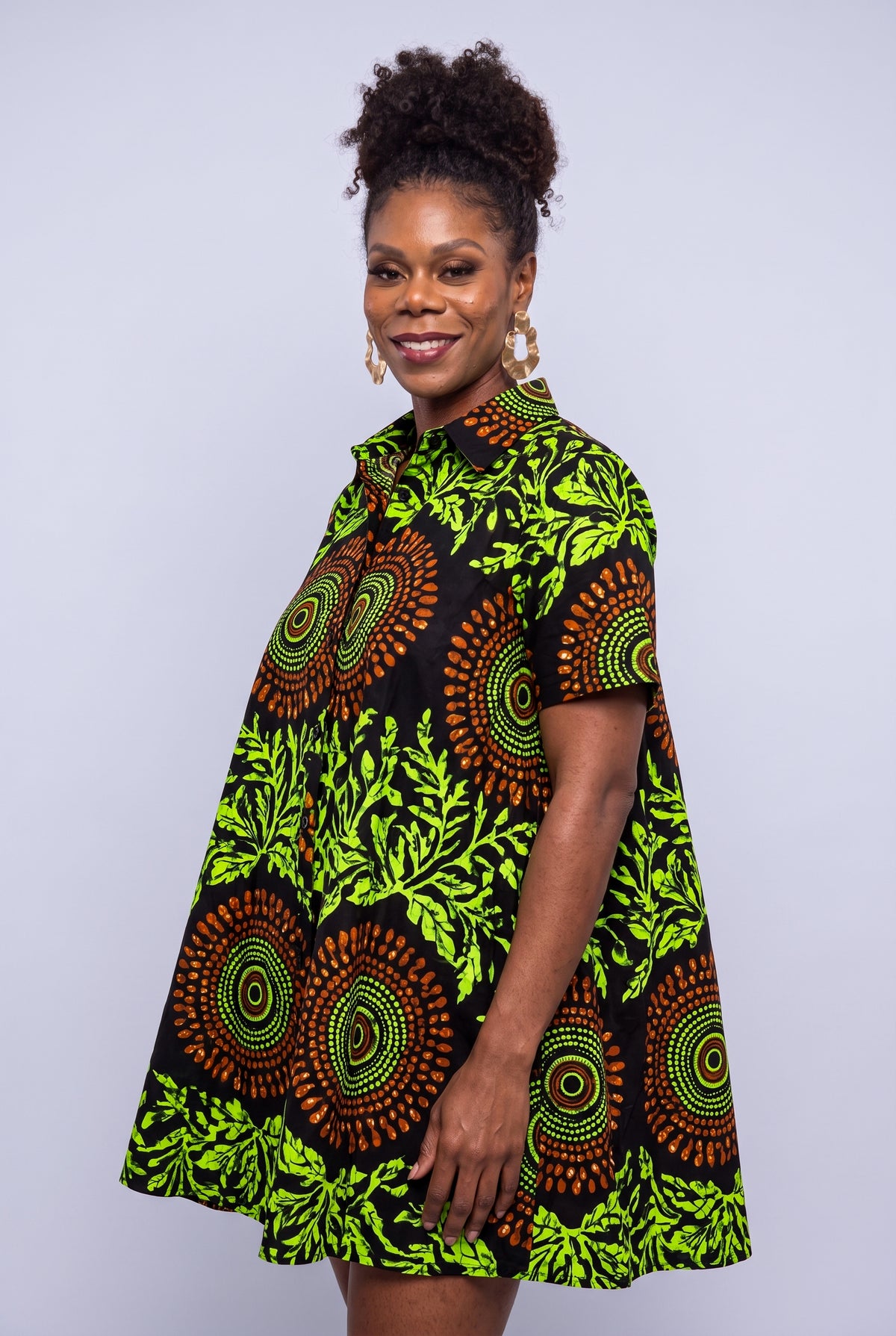 Close three quarter view of Lime Orbit black and lime green Ankara swing shirt dress with short sleeves