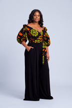 Side profile of Olive Oasis African print off shoulder wrap top styled with black palazzo trousers