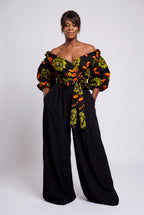 Model wearing Olive Oasis orange and green African print Ankara off shoulder wrap top with short puff sleeves