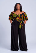 Plus size model wearing Olive Oasis orange and green Ankara wrap top with black palazzo trousers