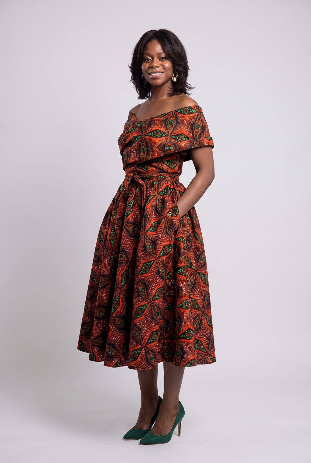 Side view of orange green navy and copper off-shoulder Ankara dress