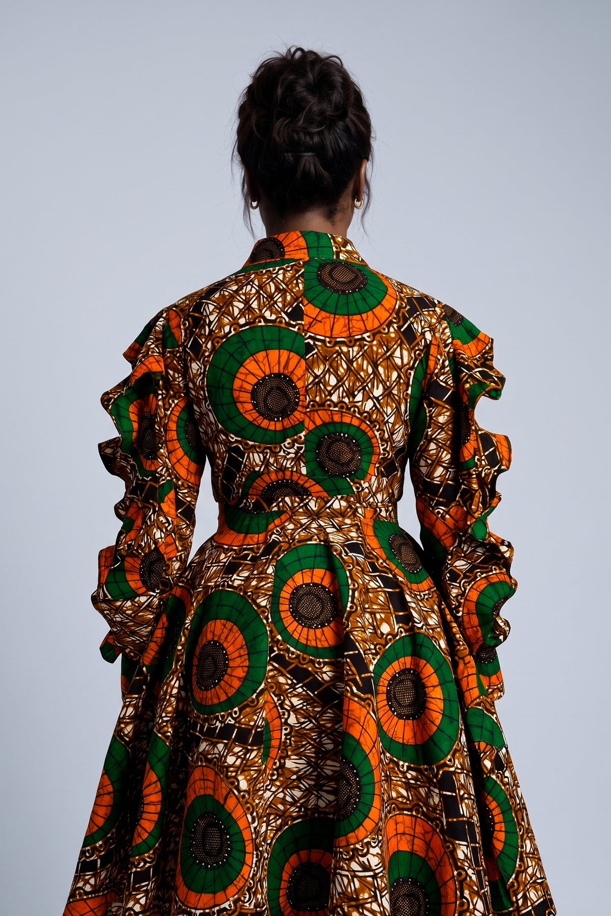 Detail view of orange green and bronze Ankara wax print fabric