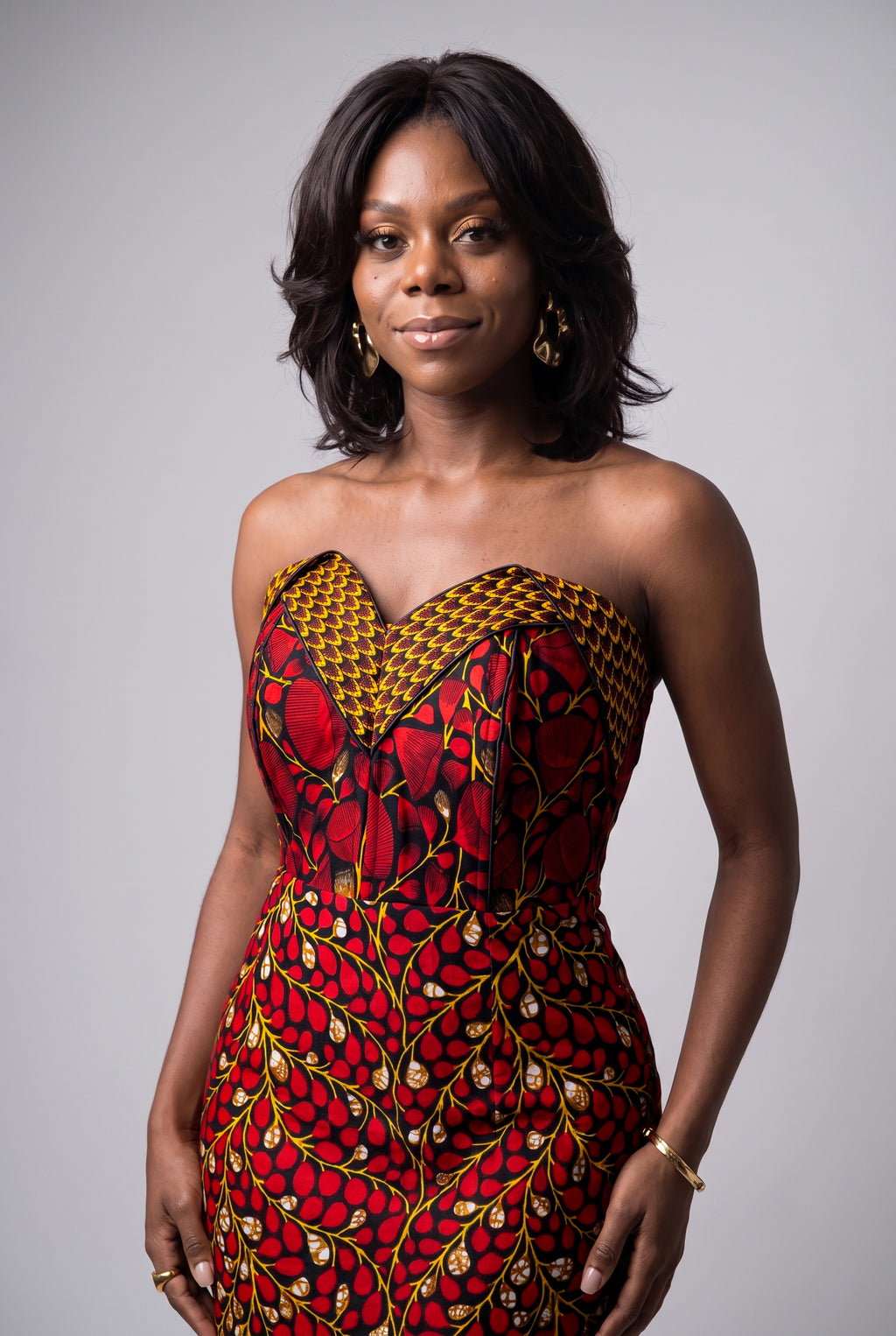 Model posing in Red Vine Ankara wedding guest corset dress
