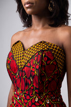 A close-up of a model wearing a strapless African wax print dress with a sweetheart neckline.