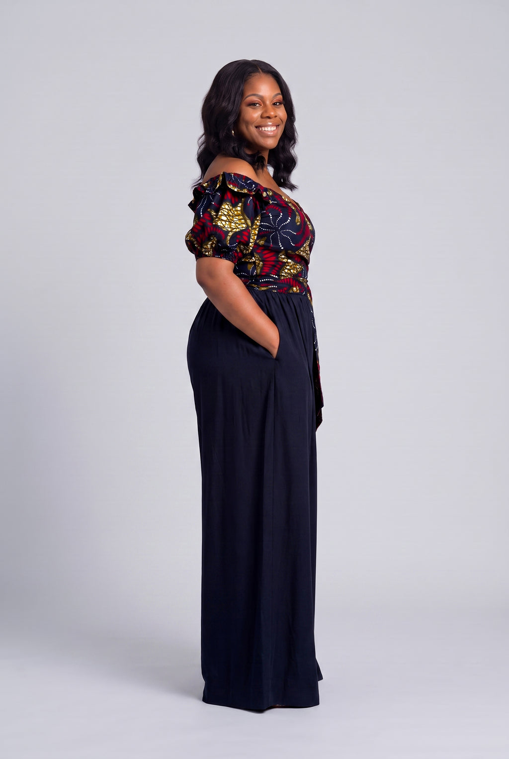 Side profile of Ruby Nova navy African print wrap top with solid navy palazzo trousers 