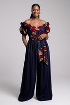 A woman styling an off-shoulder crossover Ankara blouse with high-waisted navy Palazzo trousers