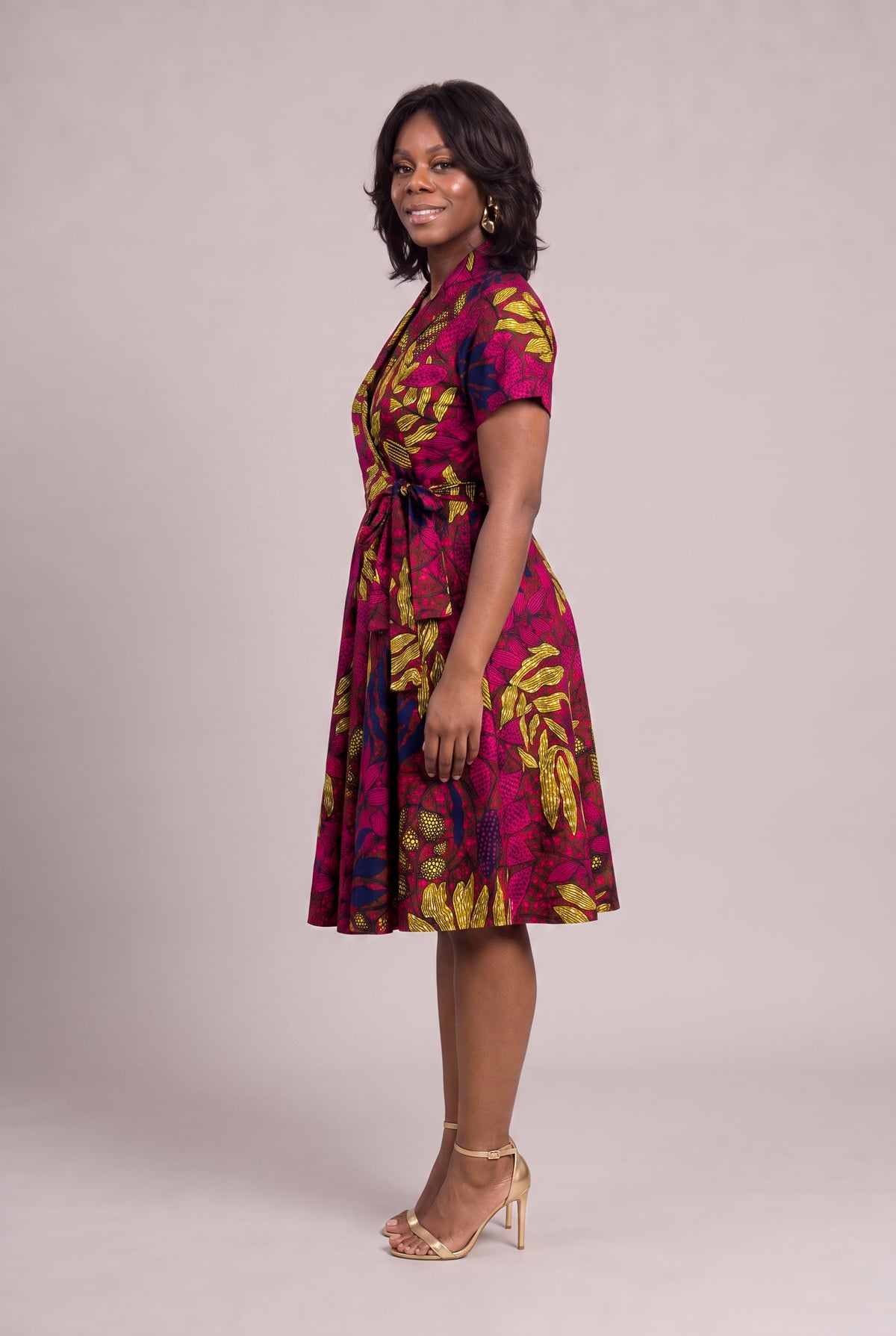Side view of magenta and gold African wrap dress