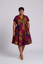 Plus size model wearing Fern Bloom pink Ankara wrap dress